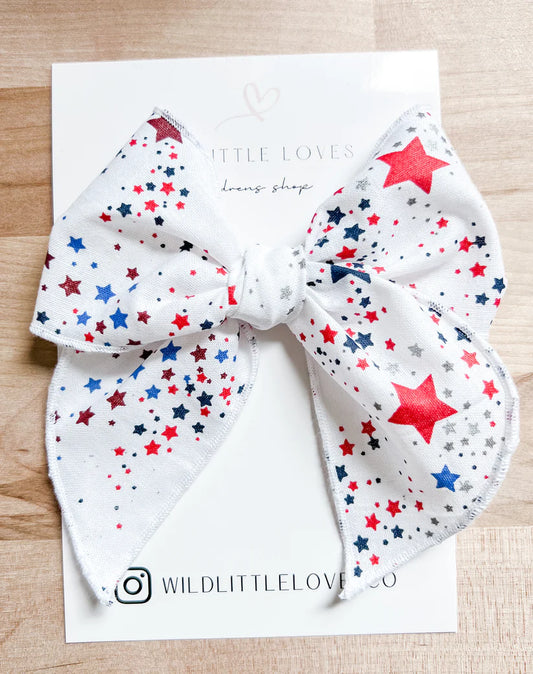 Picture of a white handtied bow with red and blue stars throughout.